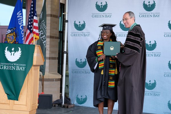 Student receives graduation diploma from Chancellor Alexander