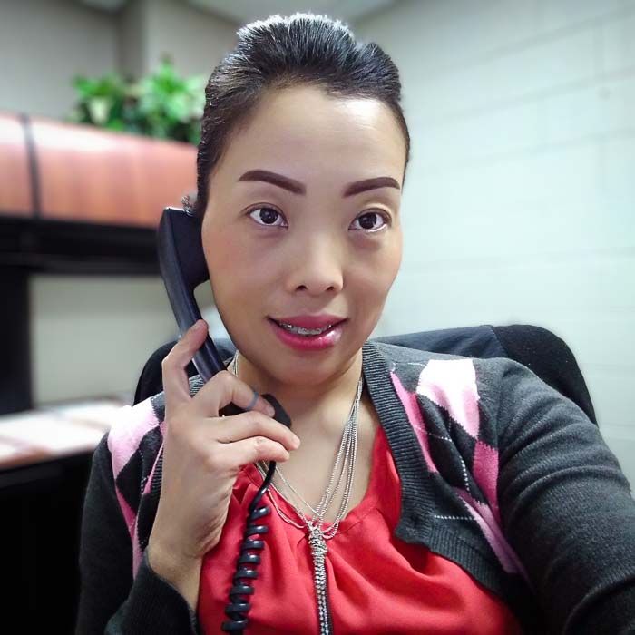 Bea Yang Thao talking on the phone at her desk