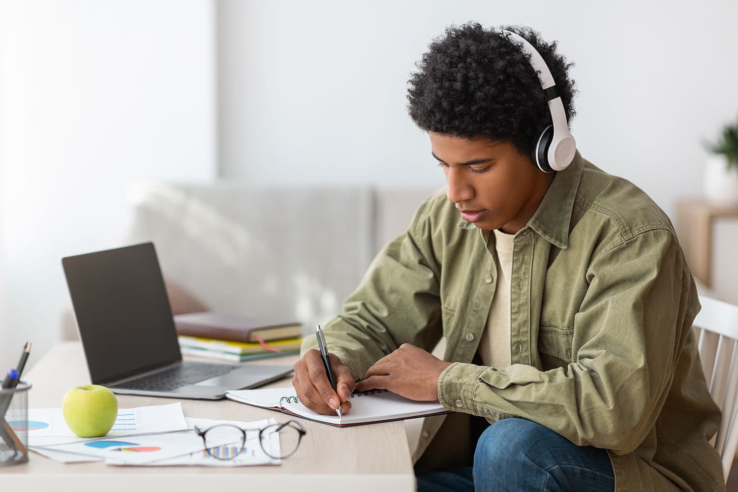 Image of a black male student studying with headphones