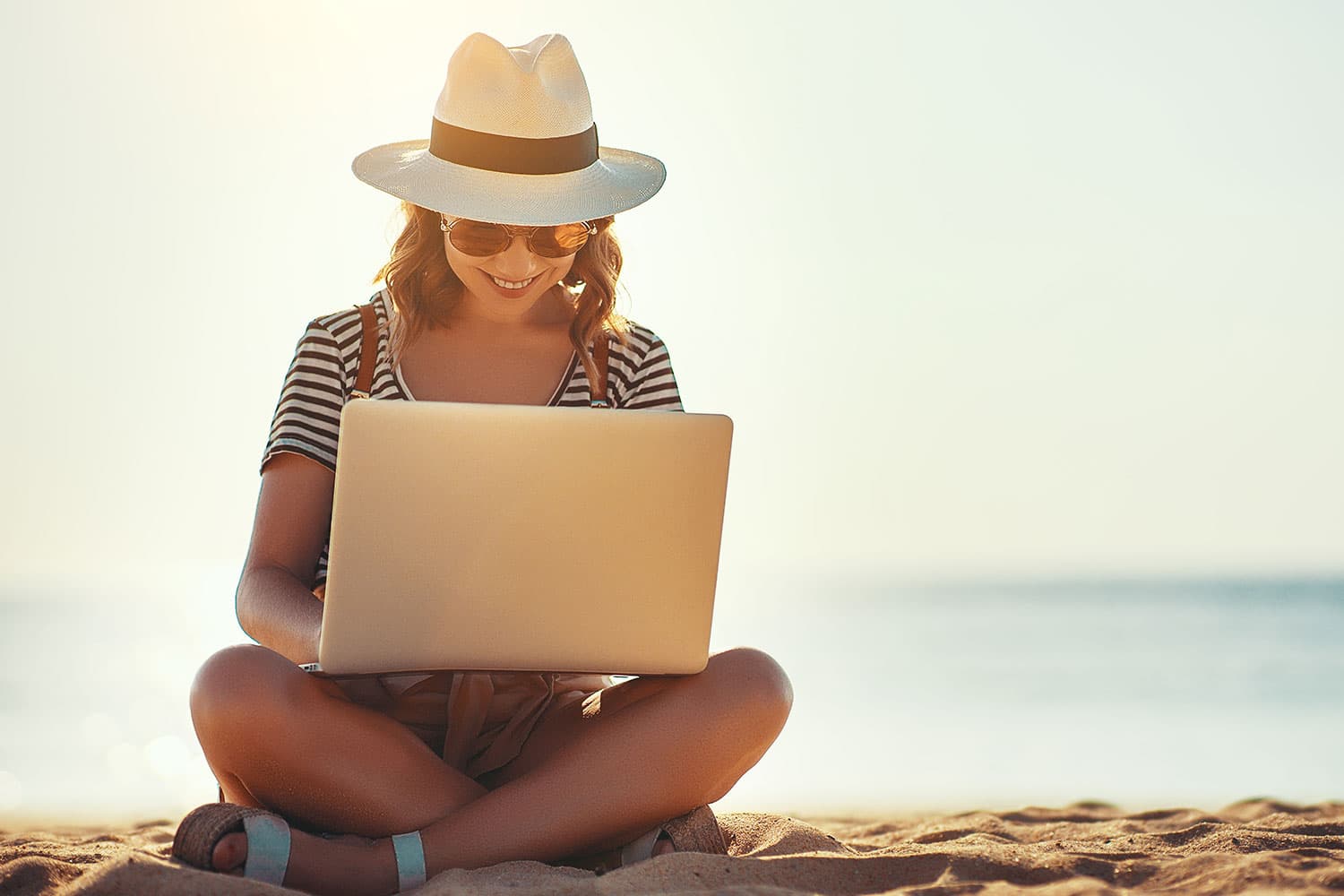Woman on the beach with a laptop
