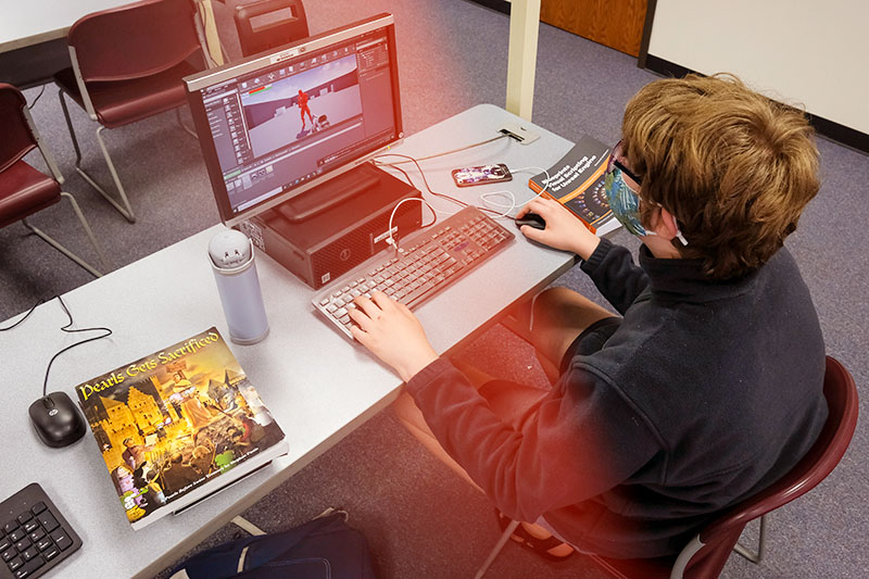 Video game programming student working at computer