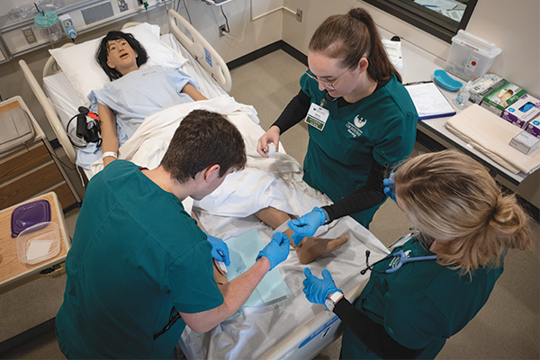 Nursing students involved in a test exercise with a practice dummy.