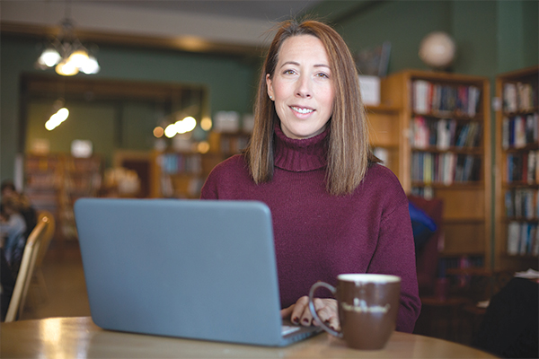 A student in a coffee shop with a laptop