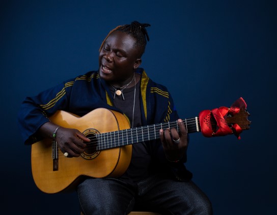 Okaidja Afroso playing guitar