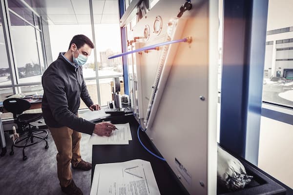 Male student takes notes on mechanical engineering projec