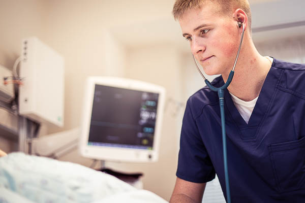 Nursing student Josh Zeitler uses stethoscope on a simulated patient