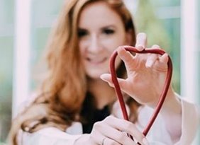 Woman holding a red stethoscope