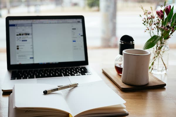 Computer and notebook open on desk