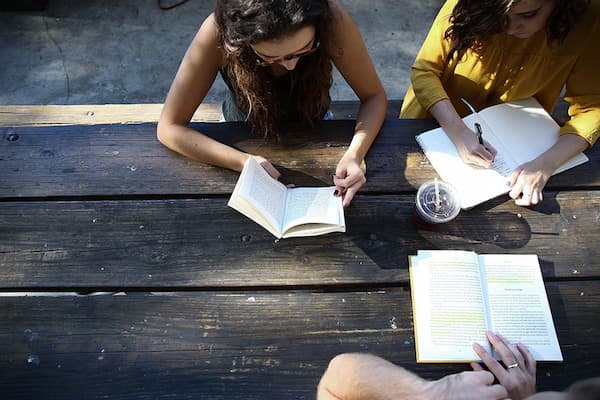 Students reading at a picnic table