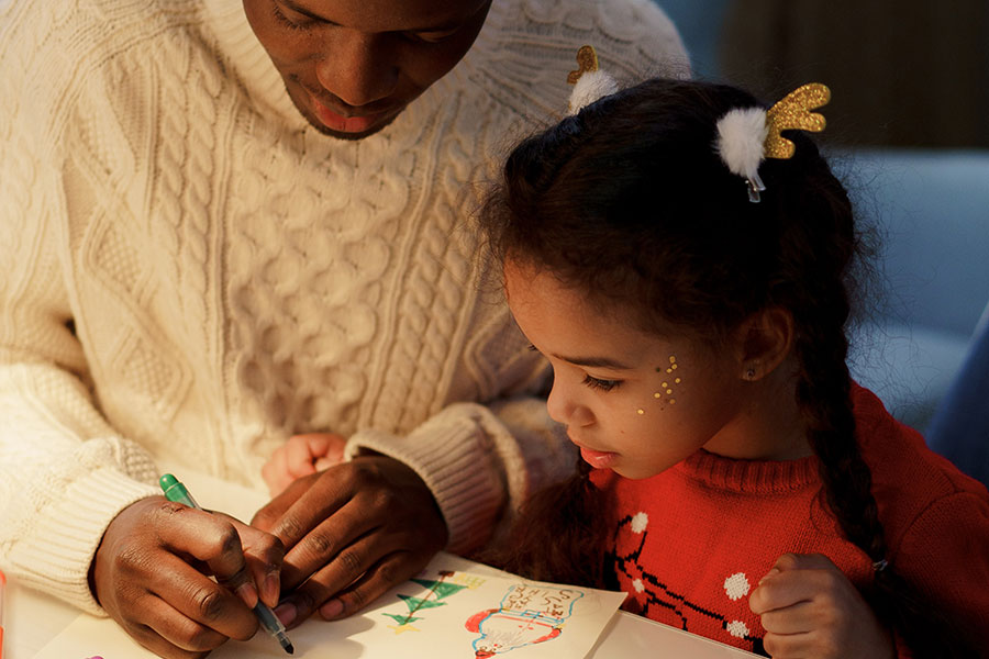 Father helping daughter with coloring