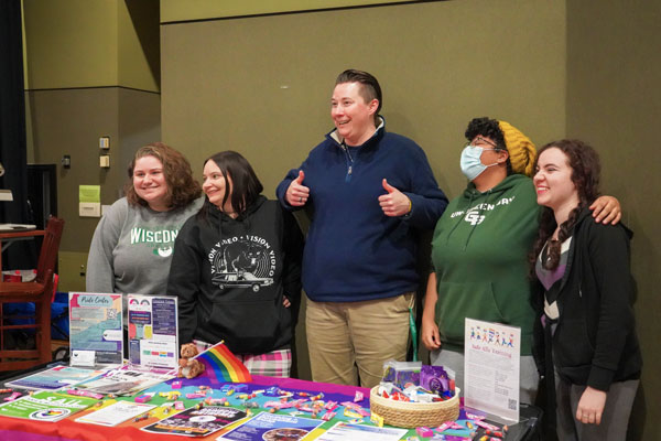 Group of students pose for photo while promoting pride