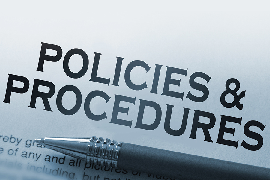 The text Policies & Procedures on paper with a pen under the text.