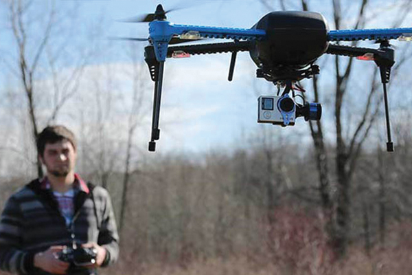 Male student flying drone outdoors