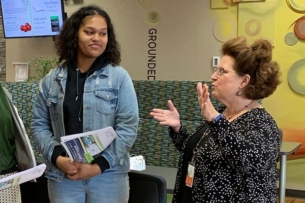 African American female speaks with faculty member