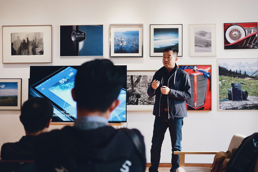 Man beside flat screen television with photos in the background