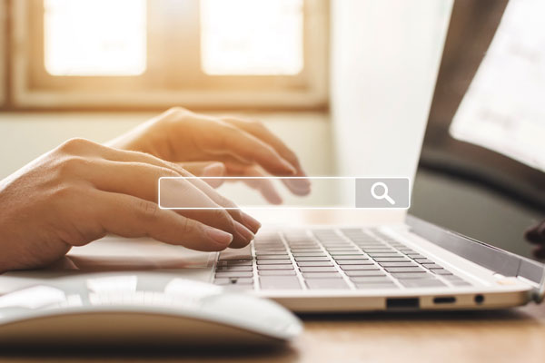 Hands typing at computer