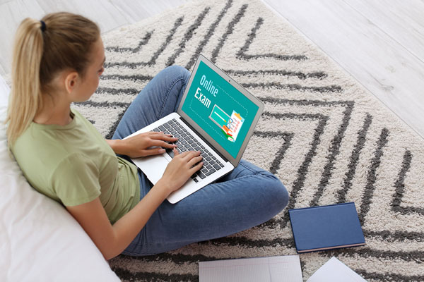 Student sitting on the floor while using laptop