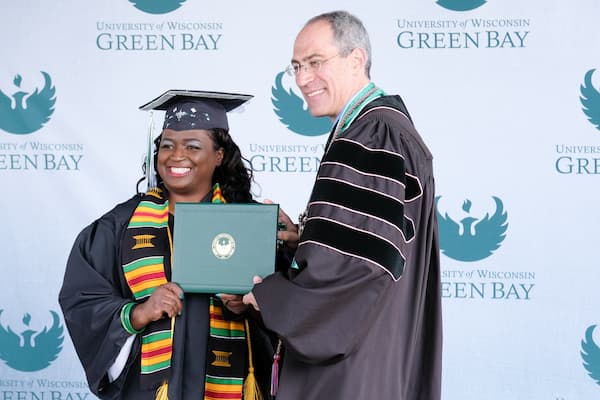 Chancellor Alexander poses with student holding diploma