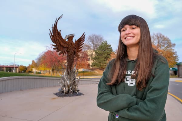 Student poses near Phoenix statue