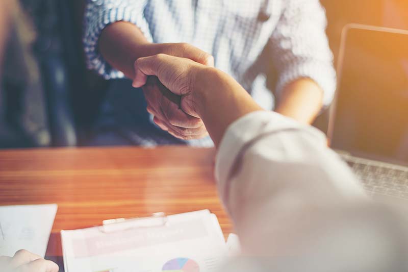 two people shaking hands during meeting