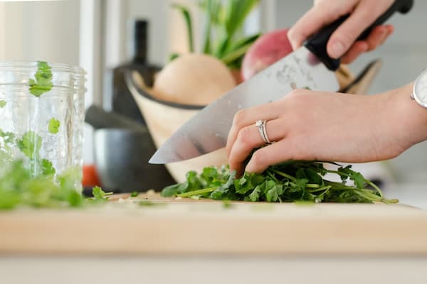 Close up of hands using knife to cute vegetables