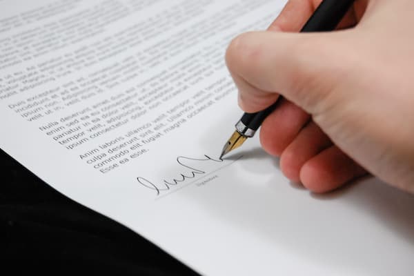 Close up of person signing resumé