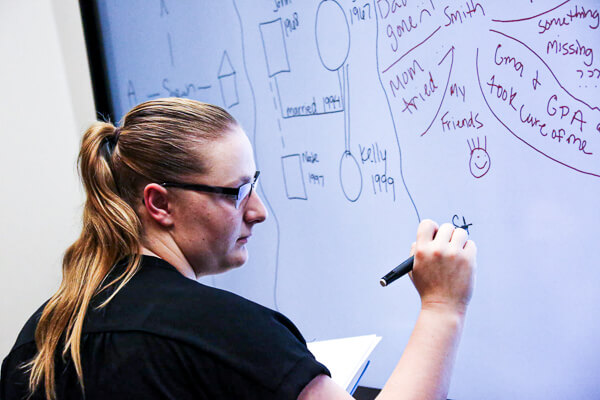 UWGB social work student completing a genogram relationship map exercise on a smart board in the UWGB Social Work Skills lab