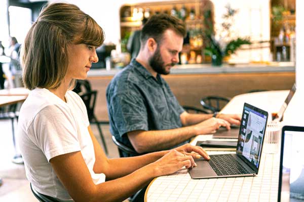 Two coworkers work on computers