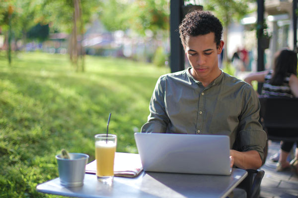 Student working on class at outdoor cafe table