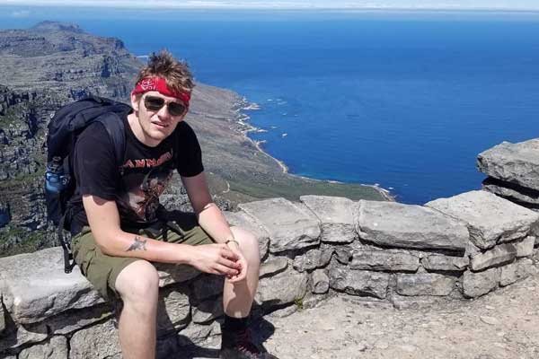 Student sits on rock ledge while studying abroad