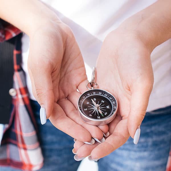 close up of woman's hand holding a compass