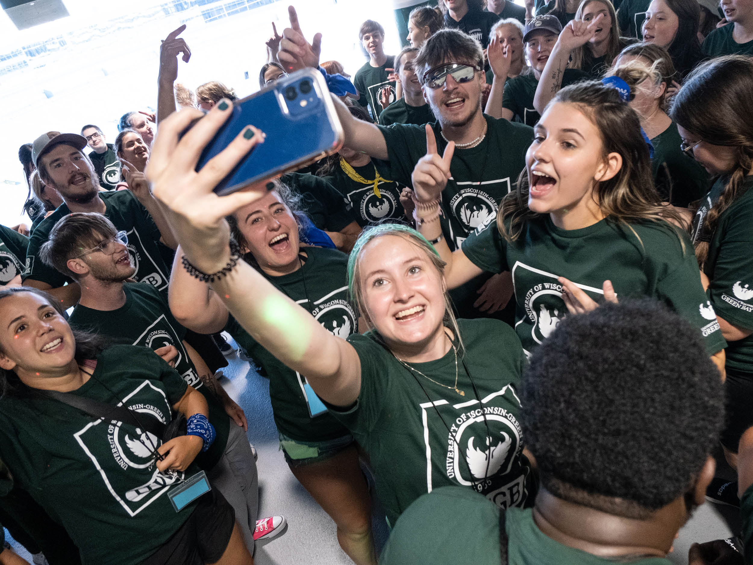 A large crowd of students gather at Lambeau Field for their civic engagement celebration in September 2022. Students in the foreground pose for a selfie.