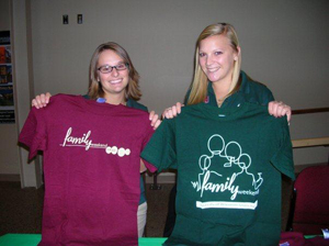 Mother and daughter on family weekend holding up shirts