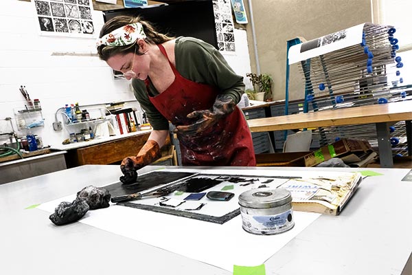Student inking a plate in a UWGB printmaking studio