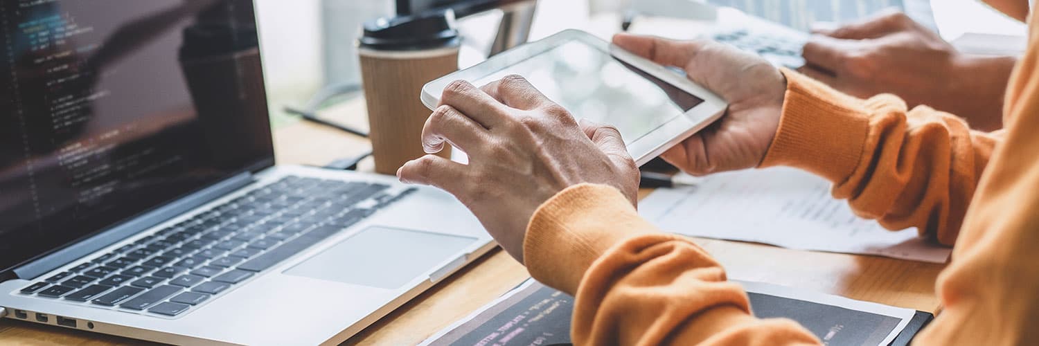 Picture of person working on computer and tablet