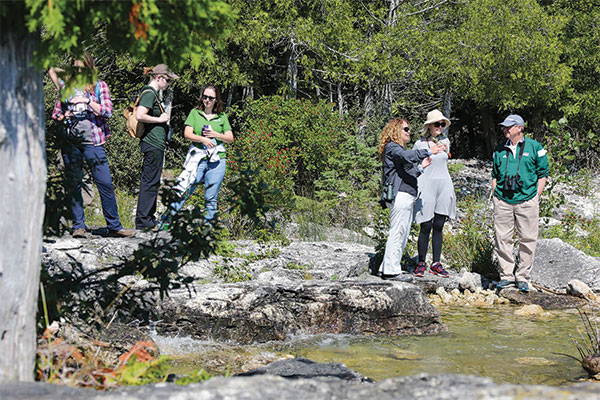 A group of students at Toft Point near water and rocks.