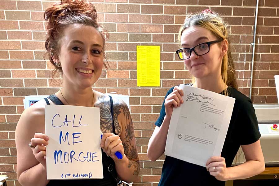 Two student hold up first draft of Call Me Morgue