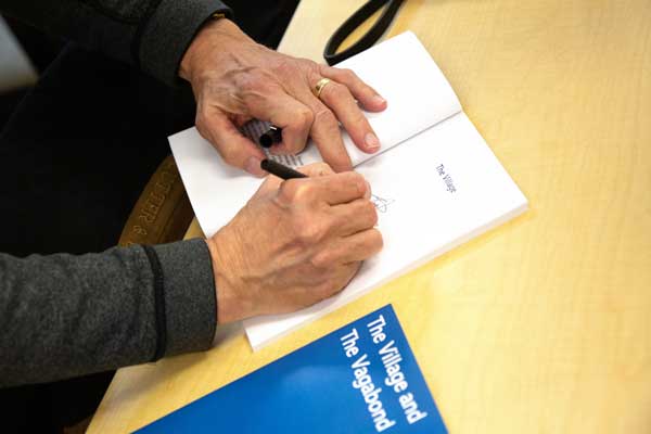 Author Tim J. Weyenberg, signs his book, The Village of Vagabond