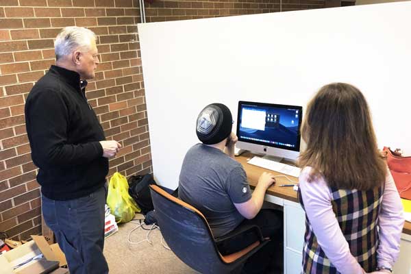 Tim Weyenberg works at iMac desktop with students