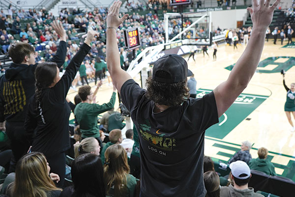 Students cheer at an athletic game in the gymnasium