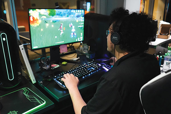 A student playing Genshin Impact on a pc