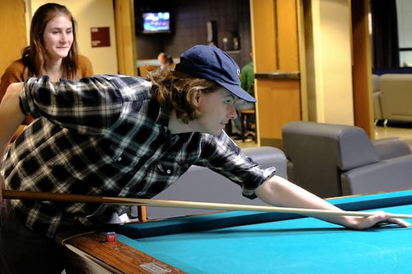 Two students playing pool at the Phoenix Club