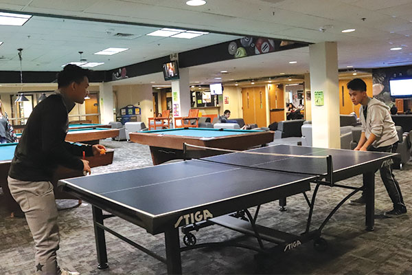 Two male students playing ping pong