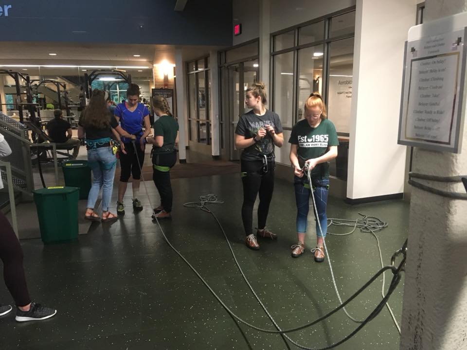 Students putting on climbing harness