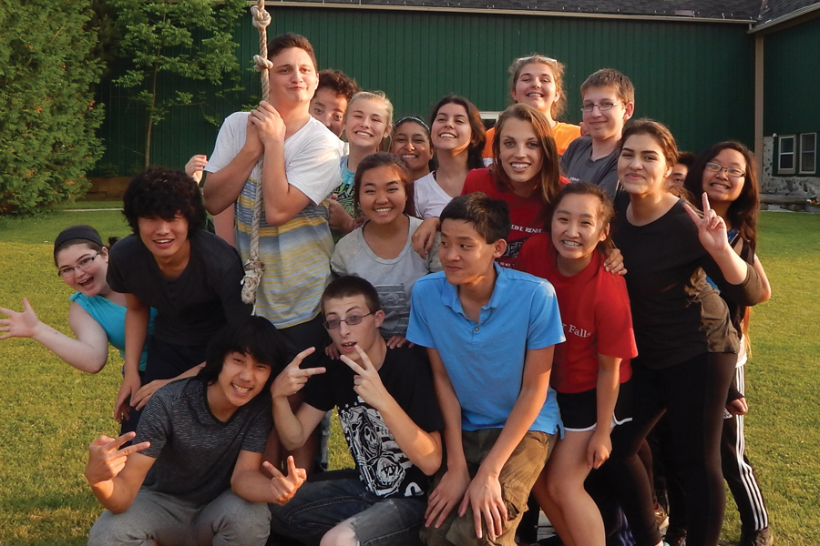 Multiple students pose for a picture outside.