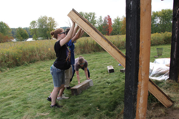 Students help push the wall up to the Viking House.