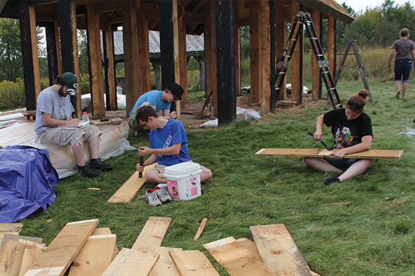 Students help label and remove nails of the Viking House walls