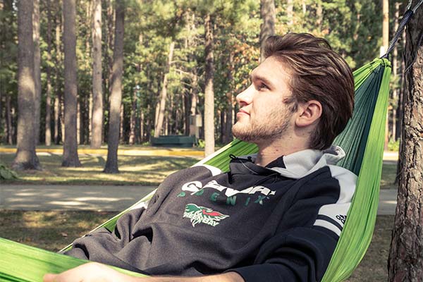 Male student in a hammock on the UWGB Marinette campus