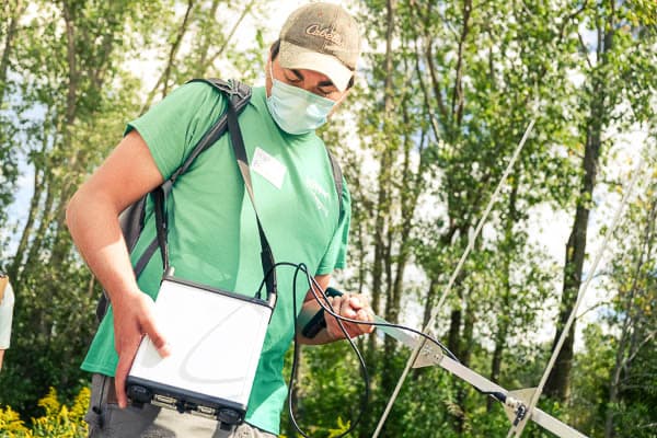 A UW-Green Bay student attends class outside doing field work.