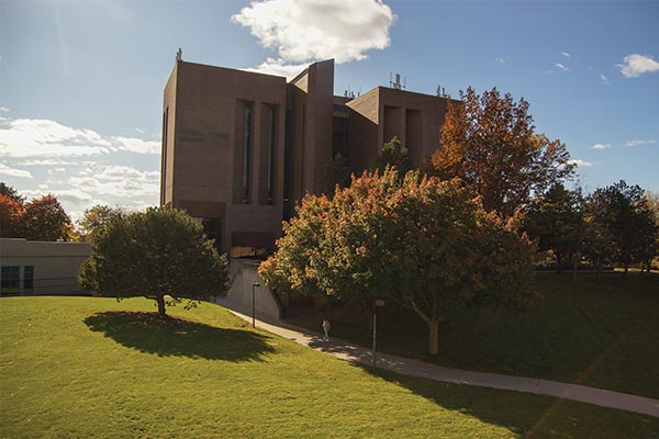 A view from the Cofrin Library looking at the Weidner Center with the bay in the background.